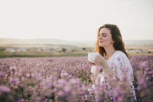 Farbe und Wellness, lila Lavendel und Frau die einen Tee trinkt